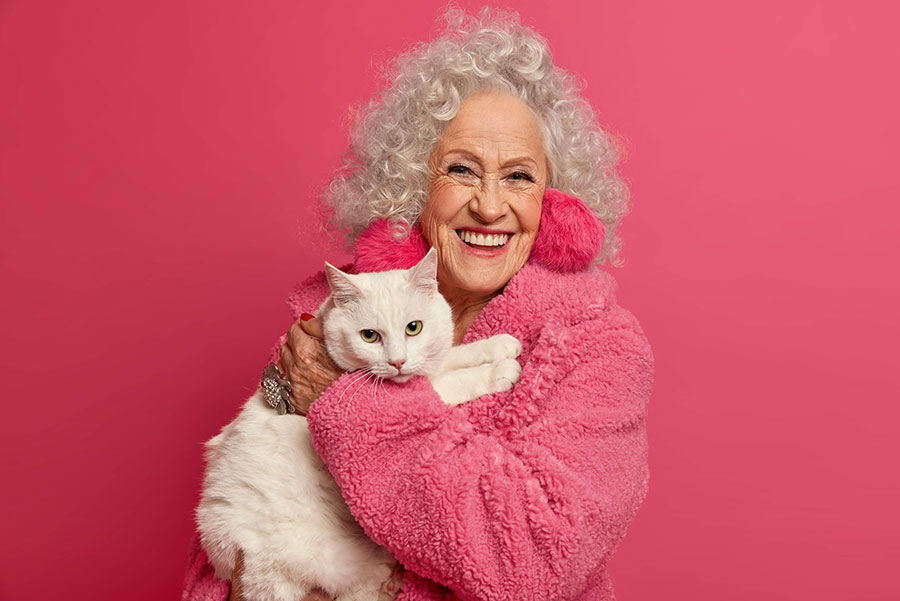 starija žena u naručju drži bijelu mačku